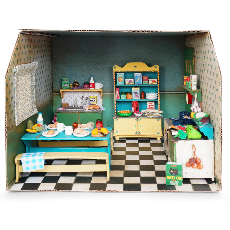 Cardboard dollhouse kitchen room with miniature furniture and accessories on checkered floor