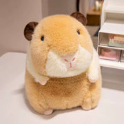 Tan capybara plush toy with white belly sitting on white surface near shelving