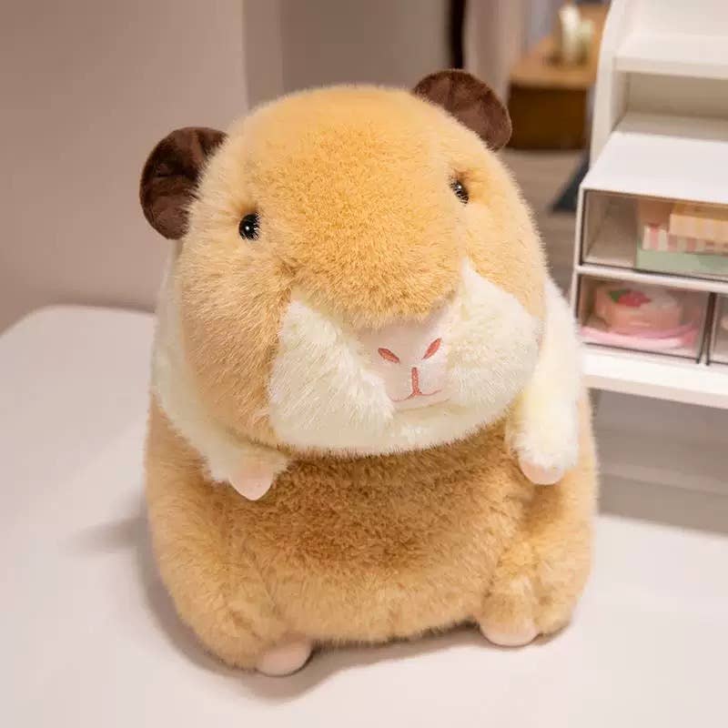 Tan capybara plush toy with white belly sitting on white surface near shelving