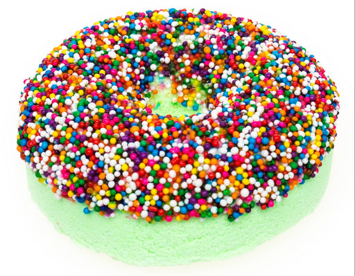Green donut-shaped bath bomb covered in colorful rainbow sprinkles on white background