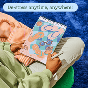 Person relaxing and working on FlowArt dot-by-letter beach themed puzzle book