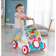 Smiling toddler pushing Hape musical activity walker with xylophone and drum on wood floor