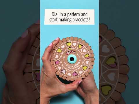 Hands holding circular Dial-a-design Bracelet Wheel with colorful pattern compartments and instruction text