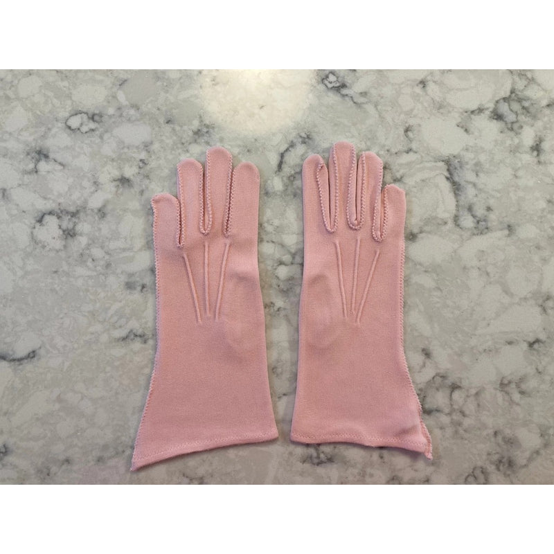 Light pink gloves with decorative stitching on marble background