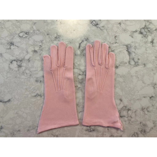 Light pink gloves with decorative stitching on marble background