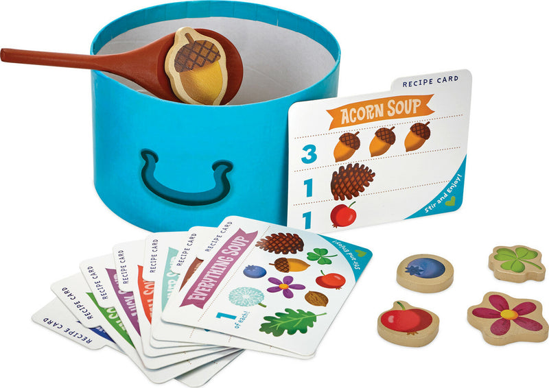 Acorn Soup children's cooking playset with blue pot, wooden spoon, recipe cards, and ingredient tokens.