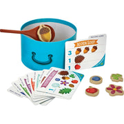 Acorn Soup children's cooking playset with blue pot, wooden spoon, recipe cards, and ingredient tokens.
