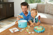 Father and child playing with Acorn Soup counting game at wooden table.