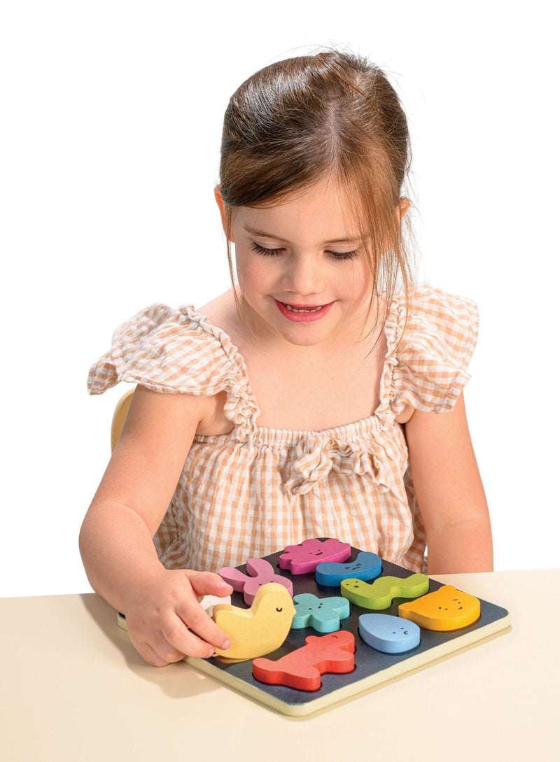 Young girl playing with colorful wooden number puzzle board toy