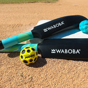 Waboba Mini Land Cracket paddles with Moon Ball and Mini Moon Ball on sandy surface