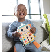 Happy child playing with colorful Blinkity Bot educational toy on couch