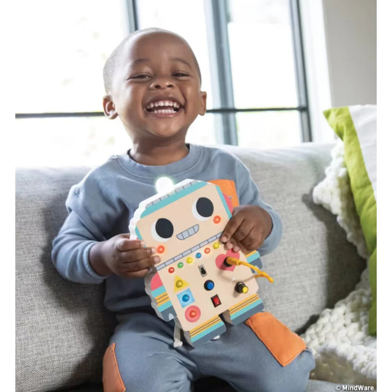 Happy child playing with colorful Blinkity Bot educational toy on couch