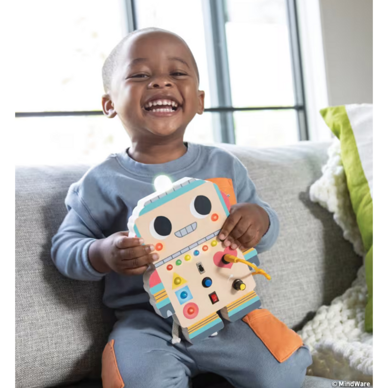 Happy child playing with colorful Blinkity Bot educational toy on couch
