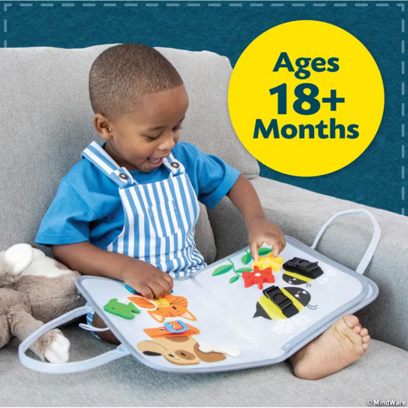 Child playing with My Busy Tote activity board on couch, ages 18+ months