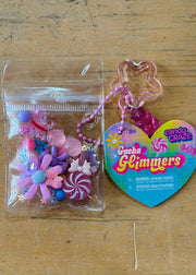 Gacha Glimmers candy craze toy with clear container of colorful beads and heart-shaped charm