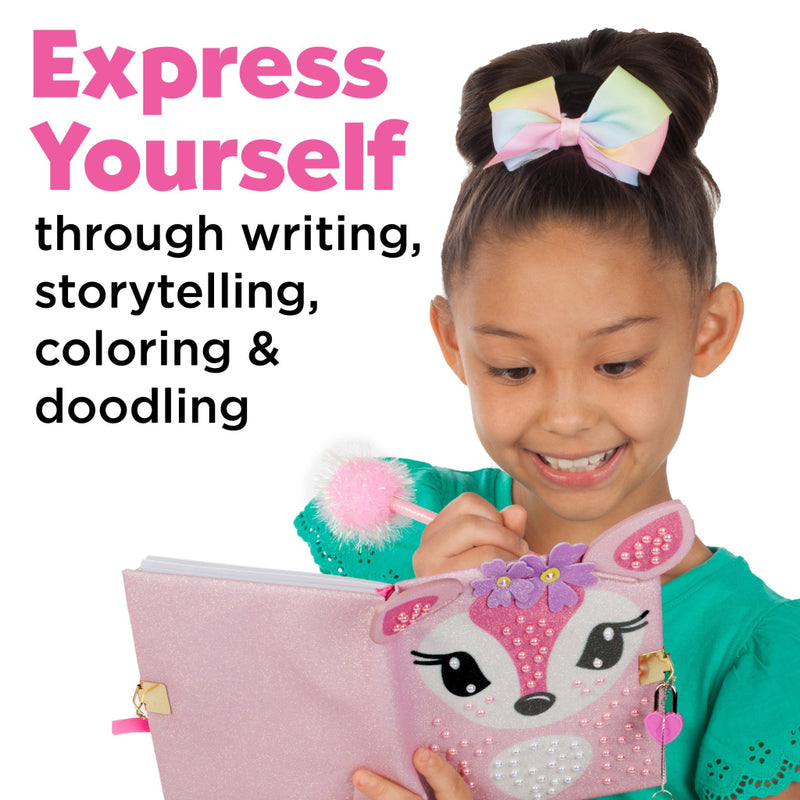 Young girl smiling while writing in pink glitter deer-themed diary with pompom pen
