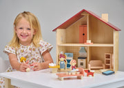 Young girl playing with Mentari Poppets Doll House wooden toy set with furniture and figures