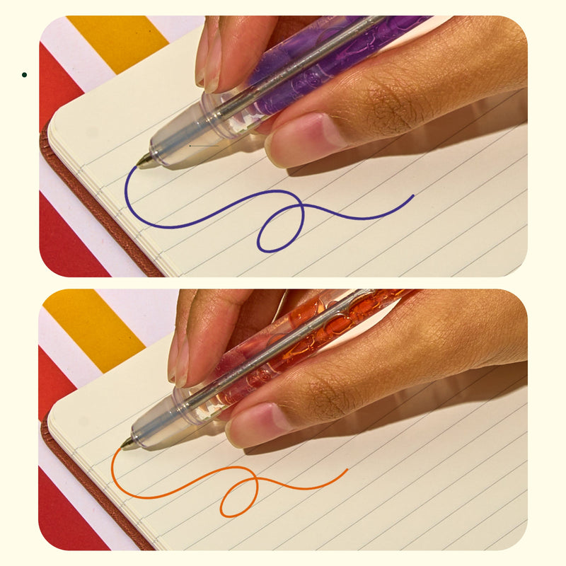 Close-up of purple and orange scented lava pens writing wavy lines on lined paper