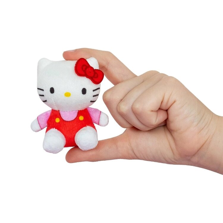 Tiny Hello Kitty plush toy held in human hand showing miniature size