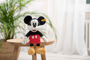 Mickey Mouse plush toy sitting on wooden stool in modern interior setting