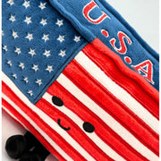 Close-up detail of American flag plush toy showing stars, stripes, and cute embroidered face