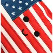 Close-up detail of American flag plush with cute embroidered face on red and white stripes