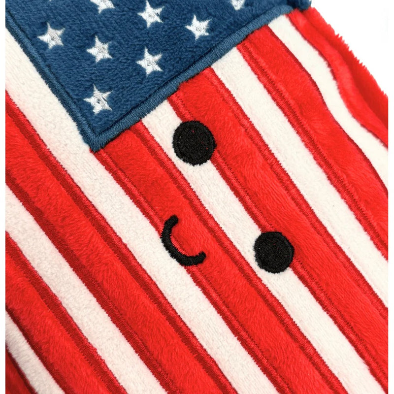 Close-up detail of American flag plush with cute embroidered face on red and white stripes