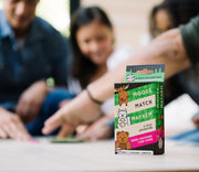 Moose Match Mayhem card game box shown with blurred family playing in background.