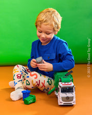 Child playing with white and green garbage recycling truck toy with light and sound features