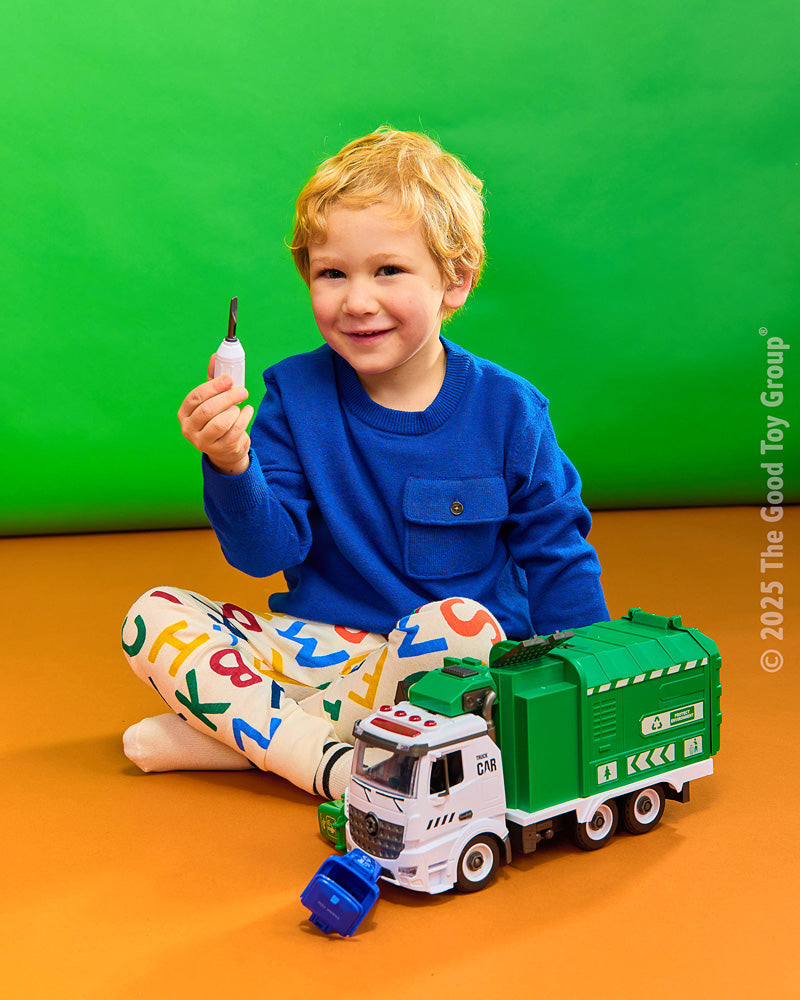 Child playing with green and white garbage recycling truck toy with remote control