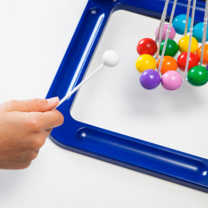 Hand operating blue Tumball game with colorful balls suspended on strings.