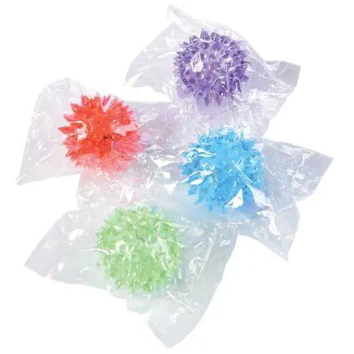 Four colorful spikey sensory balls in red, purple, blue and green on white background