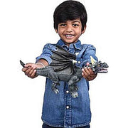 Child holding gray soft touch dragon toy while wearing denim shirt