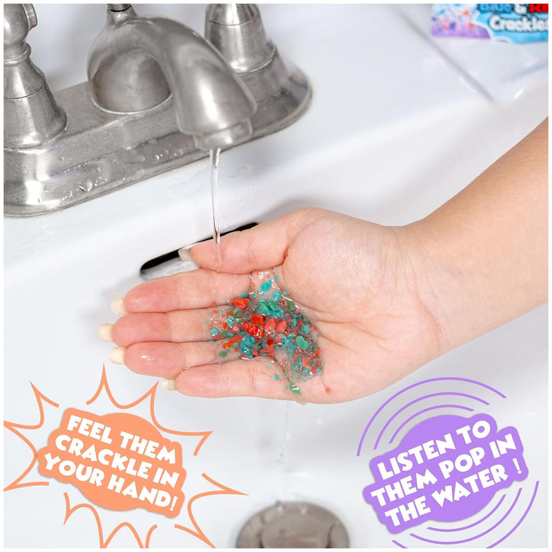 Hand holding colorful bath crackles under running water in sink demonstration
