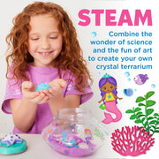 Child creating crystal mermaid terrarium with colorful crystals and underwater themed decorations