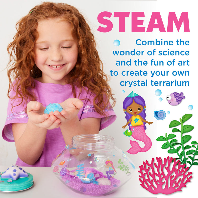 Child creating crystal mermaid terrarium with colorful crystals and underwater themed decorations